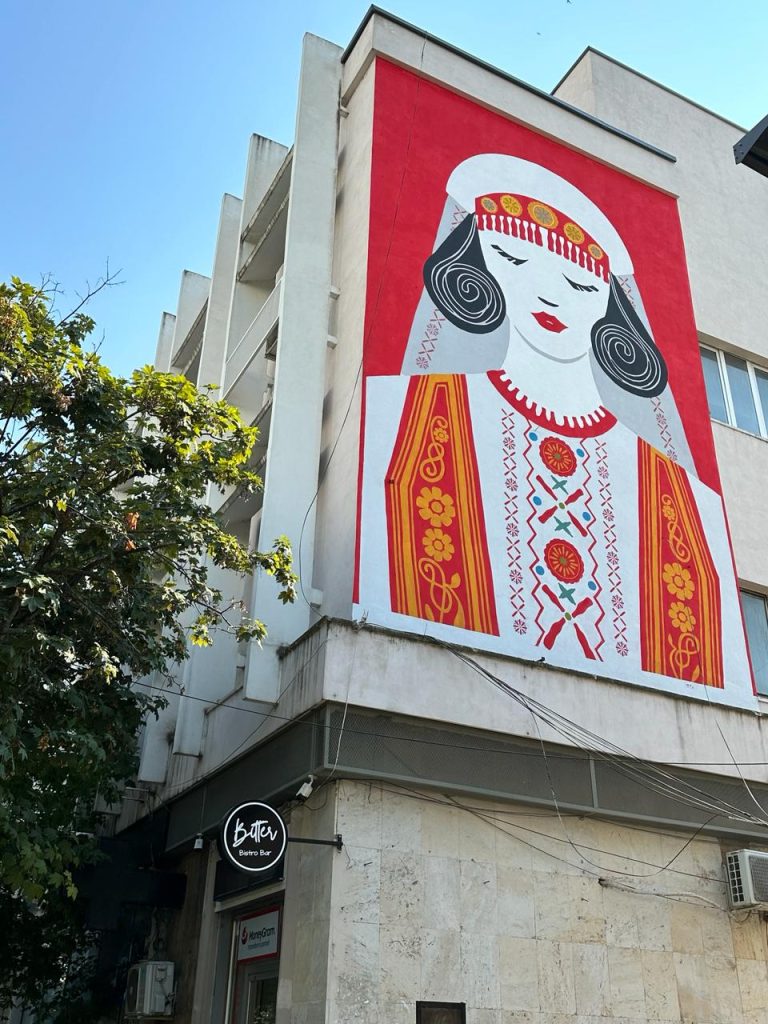 Beautiful street art in Tirana, mural of traditional girl