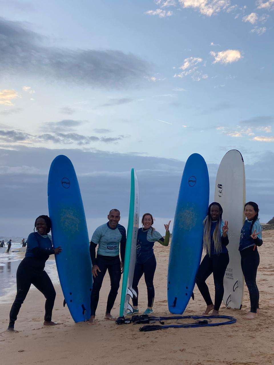 Stef Barti and a group of girls after the first surfing lesson, holding our surf boards, in Albufeira