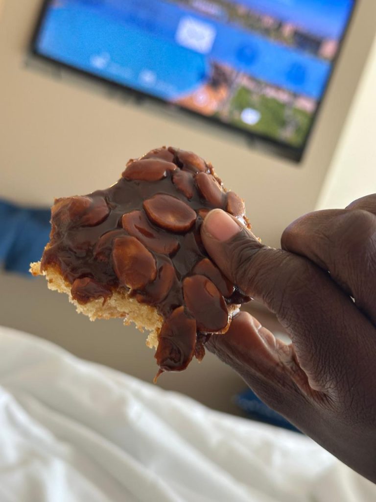 me holding a caramel almond cake I bought from the local supermarket