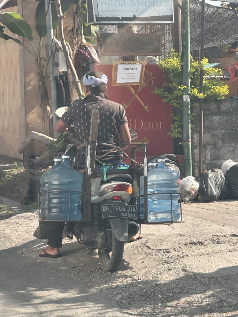 Balinese delivering water on a scooter