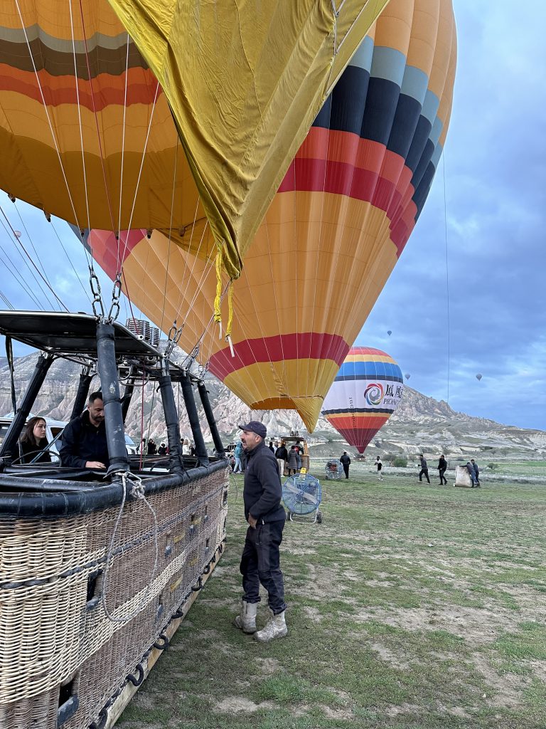 tourists getting ready to get into the hot air baloon on cappadocia