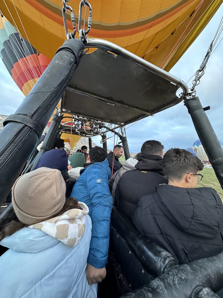 tourists hopping onto the hot air balloon in cappadocia 