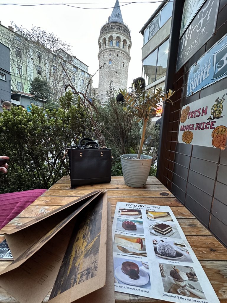 stef barti sitting inside Cesme Art Cafe in Istanbul with the view of the galata tower