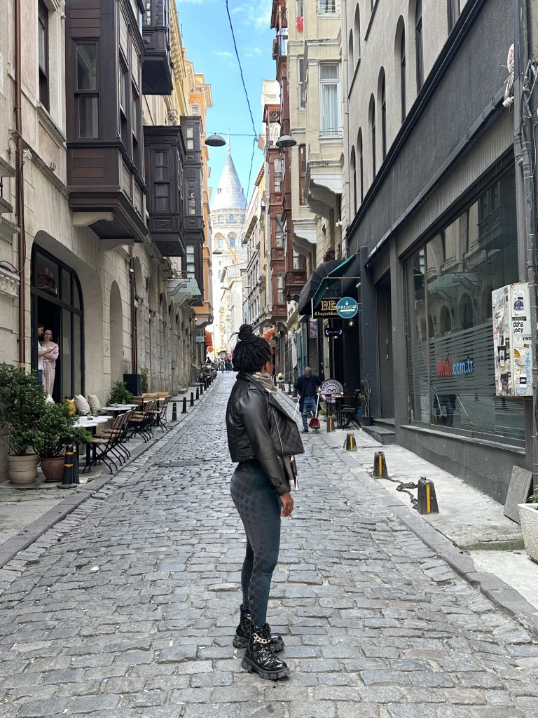 Stef barti posing in the streets of Istanbul in front of the Galata tower